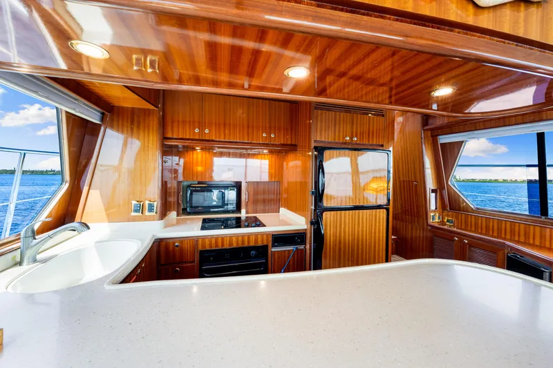 Gypsy Spirit Yacht Photos Pics Luxurious 2007 Hampton 558 Pilothouse yacht kitchen with wood finish and ocean view.