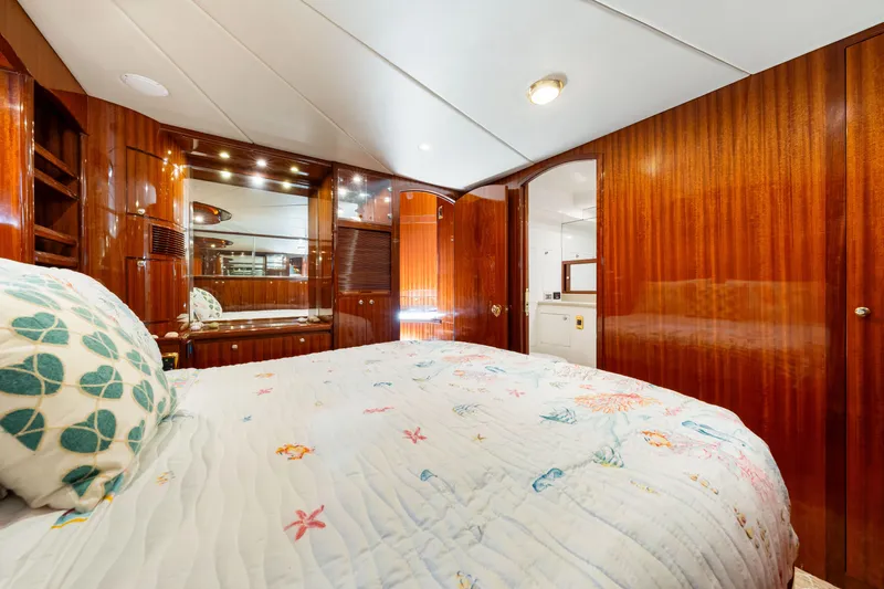 Gypsy Spirit Yacht Photos Pics Luxurious bedroom interior of 2007 Hampton 558 Pilothouse yacht with wood paneling and cozy bedding.