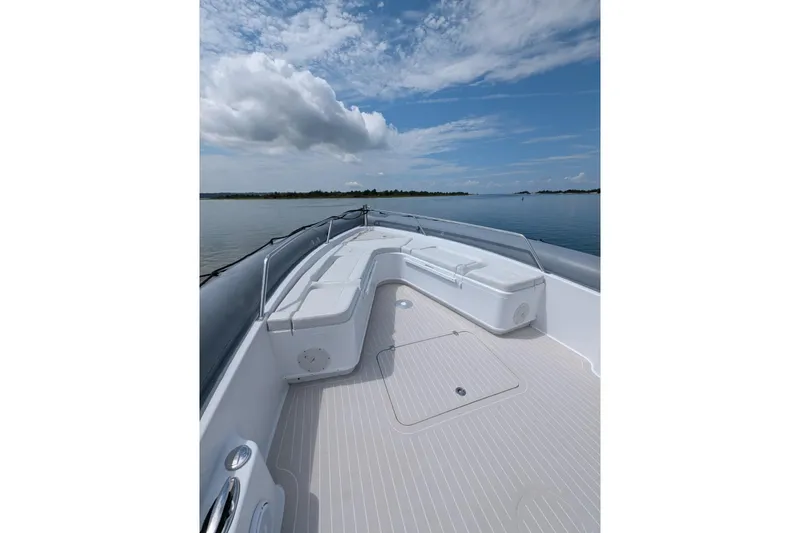 Yellowfin Yacht Photos Pics 2015 Yellowfin RIB boat deck with seating, calm water, and cloudy sky.