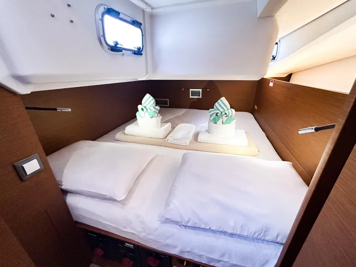 Air Guitar Yacht Photos Pics Luxurious cabin interior of 2024 Jeanneau Sun Odyssey 440 yacht with neatly arranged bedding.