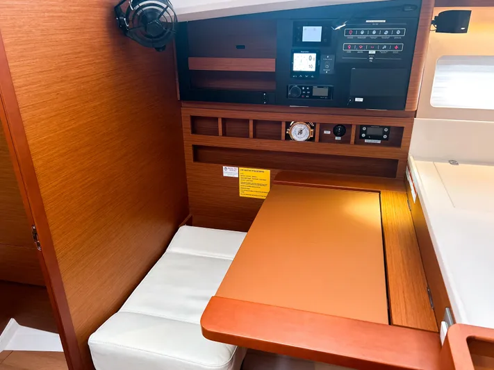 Air Guitar Yacht Photos Pics 2024 Jeanneau Sun Odyssey 440 interior with navigation station and wooden finish.
