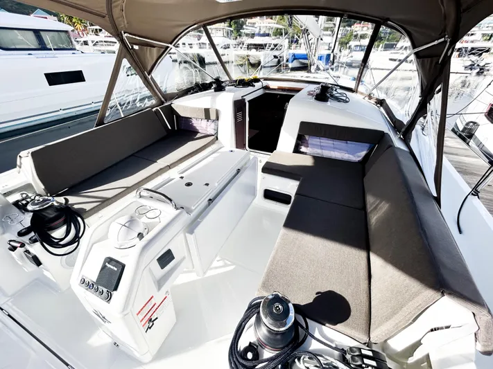 Air Guitar Yacht Photos Pics 2024 Jeanneau Sun Odyssey 440 cockpit with seating, winches, and canopy in marina setting.
