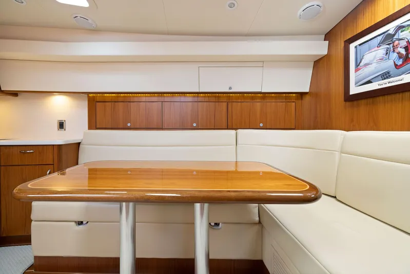 Lil Fella Yacht Photos Pics Luxurious interior of 2012 Cabo 44 Hardtop Express yacht with wooden table and cream seating.