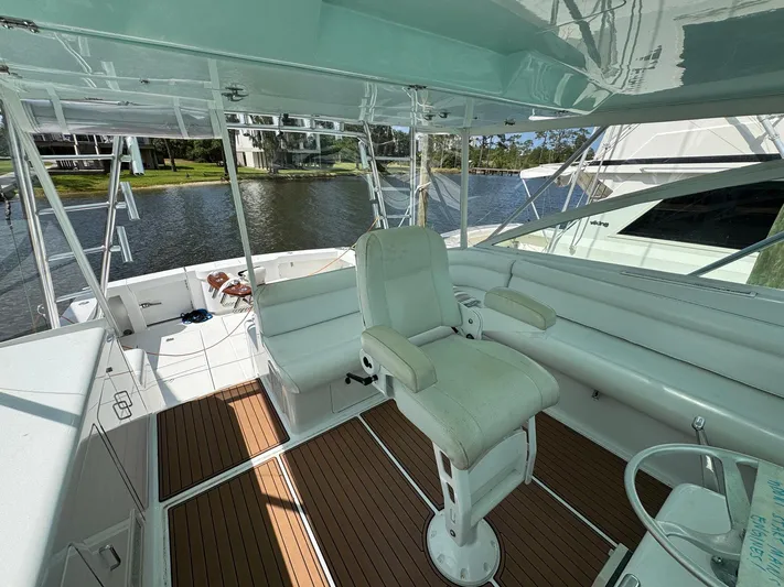  Yacht Photos Pics 1999 Cabo 45 Express yacht interior with helm seat and spacious deck.