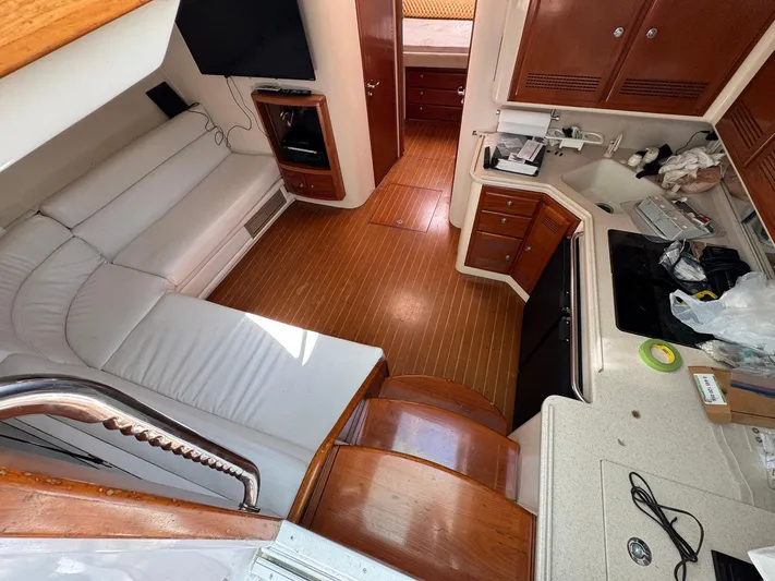  Yacht Photos Pics Interior of a 1999 Cabo 45 Express yacht with white seating and wooden cabinetry.