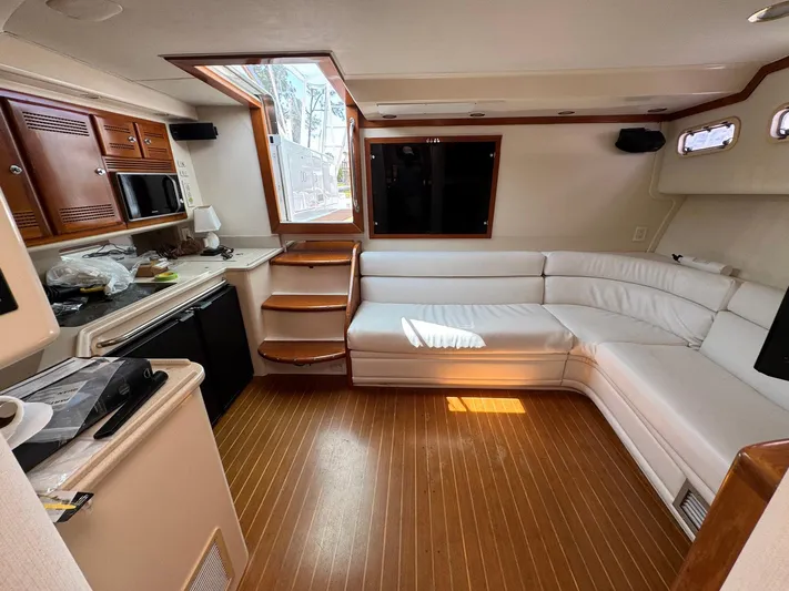  Yacht Photos Pics Interior of 1999 Cabo 45 Express yacht with white seating and wooden flooring.