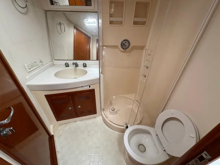  Yacht Photos Pics Bathroom interior of 1999 Cabo 45 Express yacht with shower, sink, and toilet.