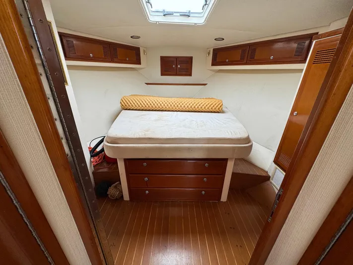  Yacht Photos Pics 1999 Cabo 45 Express cabin interior with bed, wooden cabinets, and overhead hatch.