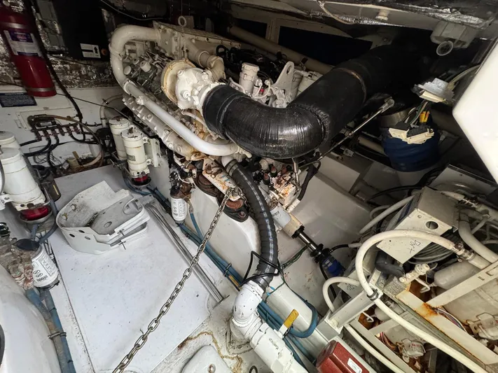  Yacht Photos Pics Engine room of a 1999 Cabo 45 Express boat, showcasing mechanical components and piping.