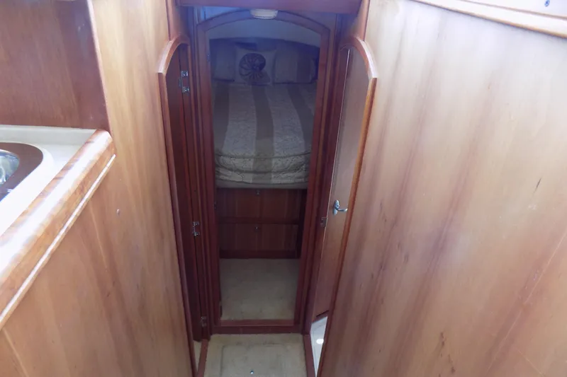  Yacht Photos Pics 2004 Mainship 390 Trawler interior with wooden cabinetry and cozy sleeping quarters.