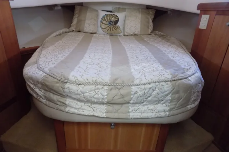  Yacht Photos Pics Cozy cabin bed in 2004 Mainship 390 Trawler with elegant bedding and wooden accents.