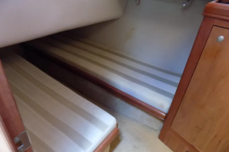  Yacht Photos Pics 2004 Mainship 390 Trawler cabin with twin striped beds and wooden cabinetry.