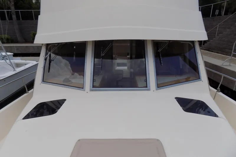  Yacht Photos Pics 2004 Mainship 390 Trawler front view with large windows and sleek design.