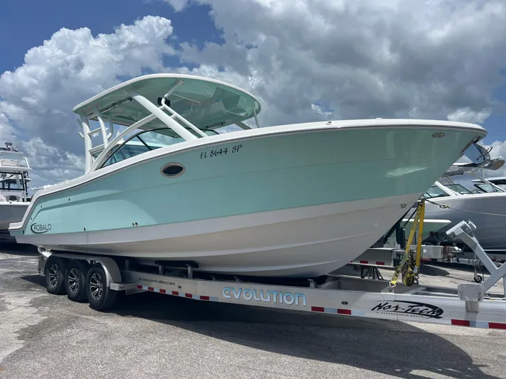  Yacht Photos Pics 2020 Robalo R317 Dual Console boat on trailer under cloudy sky.