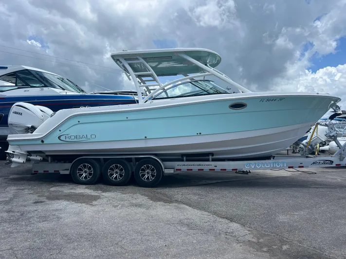  Yacht Photos Pics 2020 Robalo R317 Dual Console boat on a trailer under cloudy sky.