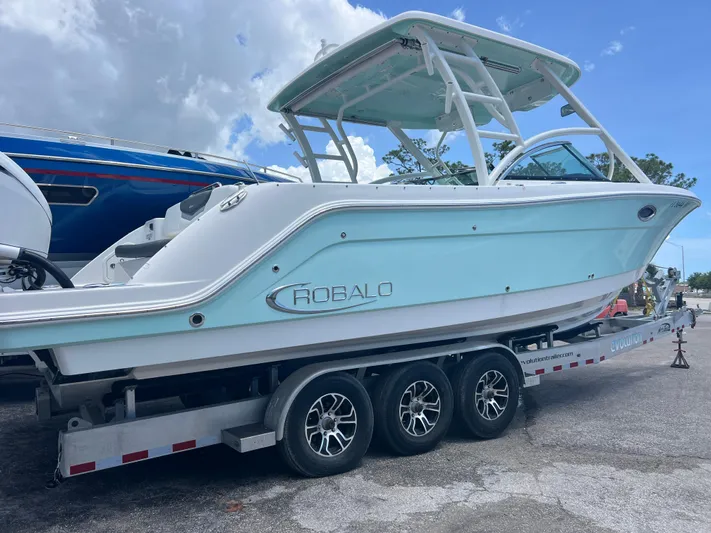 Yacht Photos Pics 2020 Robalo R317 Dual Console boat on a trailer, light blue hull, parked outdoors.