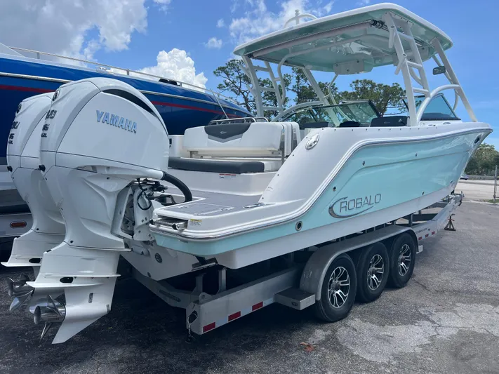  Yacht Photos Pics 2020 Robalo R317 Dual Console boat on trailer with Yamaha engines, parked outdoors.