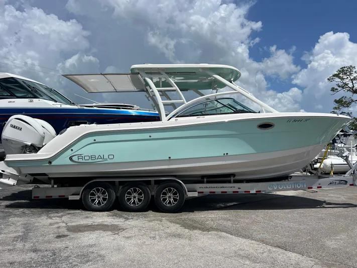  Yacht Photos Pics 2020 Robalo R317 Dual Console boat on trailer under cloudy sky.