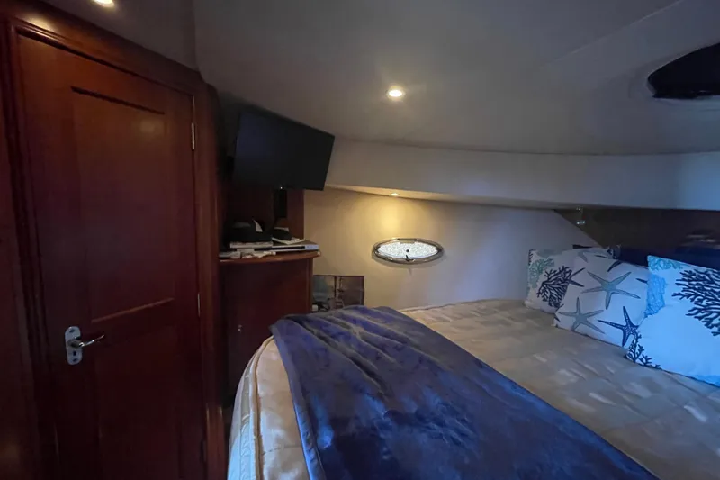 Born Free Yacht Photos Pics Interior of 2007 Silverton 38 Convertible yacht bedroom with cozy bedding and TV.