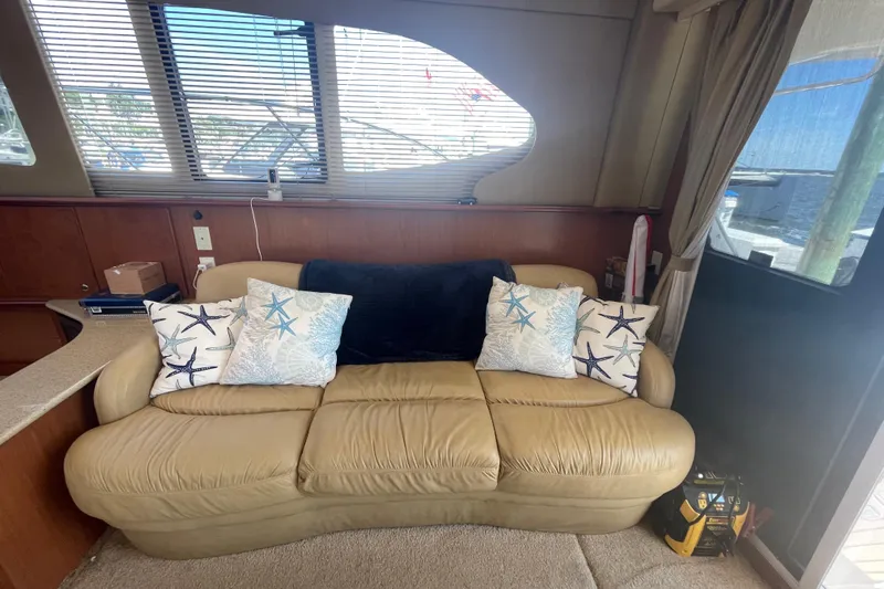Born Free Yacht Photos Pics Interior of 2007 Silverton 38 Convertible with beige sofa and starfish-themed pillows.