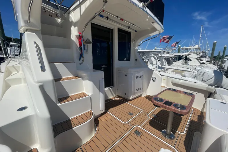 Born Free Yacht Photos Pics 2007 Silverton 38 Convertible yacht interior with stairs, table, and docked boats in background.