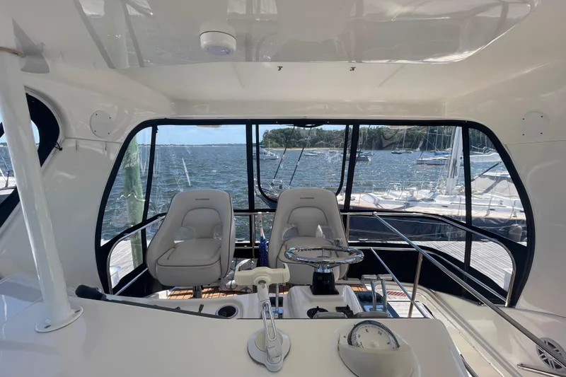 Born Free Yacht Photos Pics 2007 Silverton 38 Convertible yacht interior with helm and seating, overlooking marina.