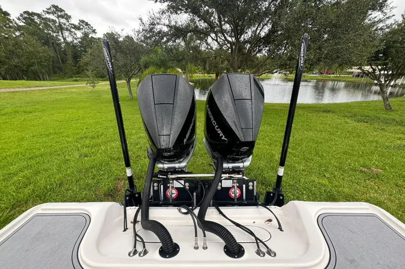  Yacht Photos Pics 2023 Tidewater 2700 Carolina Bay boat with dual Mercury engines by a pond.