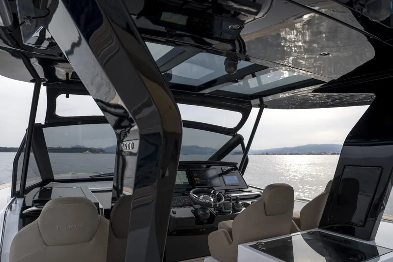  Yacht Photos Pics 2024 Pardo Yachts P50 helm with modern controls, overlooking serene water and distant hills.