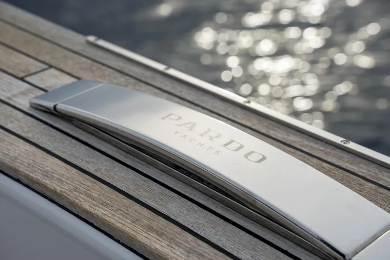  Yacht Photos Pics 2024 Pardo Yachts P50 detail with sleek metal handle and wooden deck, ocean in background.