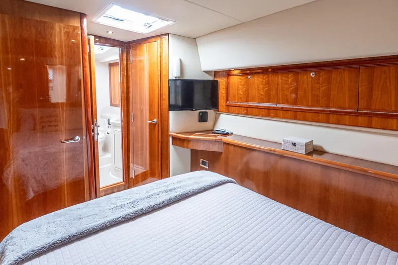 Chillax Yacht Photos Pics Luxurious 2005 Riviera 51 Flybridge yacht bedroom with wood paneling and modern amenities.