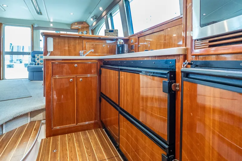 Chillax Yacht Photos Pics Luxurious 2005 Riviera 51 Flybridge yacht interior with polished wood cabinetry and modern appliances.