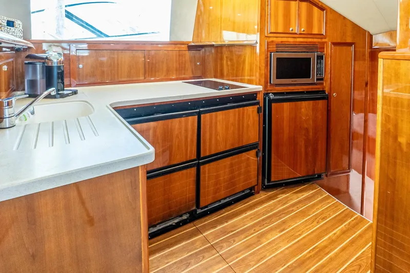 Chillax Yacht Photos Pics Luxurious 2005 Riviera 51 Flybridge yacht kitchen with wood cabinetry and modern appliances.