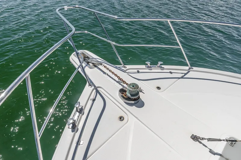 Chillax Yacht Photos Pics Bow of 2005 Riviera 51 Flybridge yacht with anchor chain and railing on water.