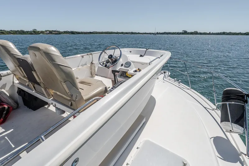 Chillax Yacht Photos Pics 2005 Riviera 51 Flybridge boat interior with steering wheel, seats, and ocean view.