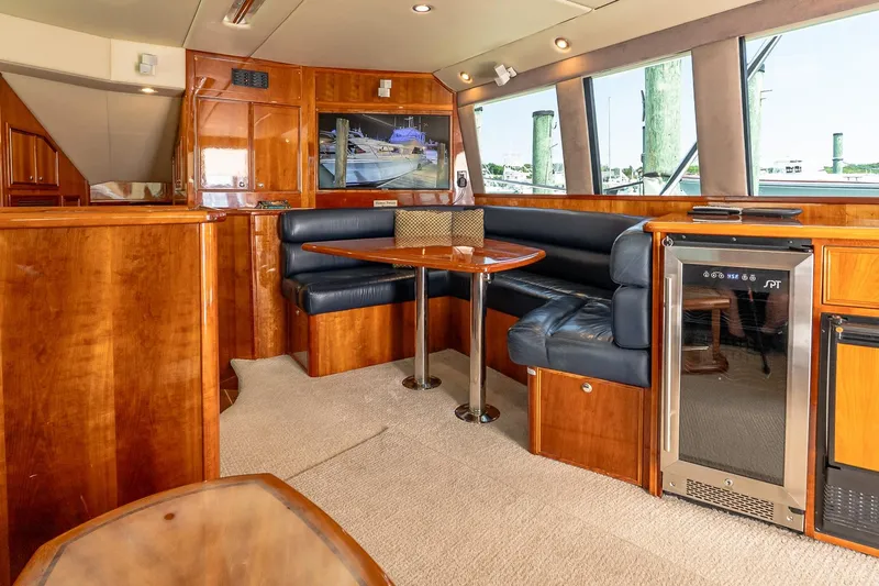 Chillax Yacht Photos Pics Luxurious interior of 2005 Riviera 51 Flybridge yacht with wood finish and leather seating.