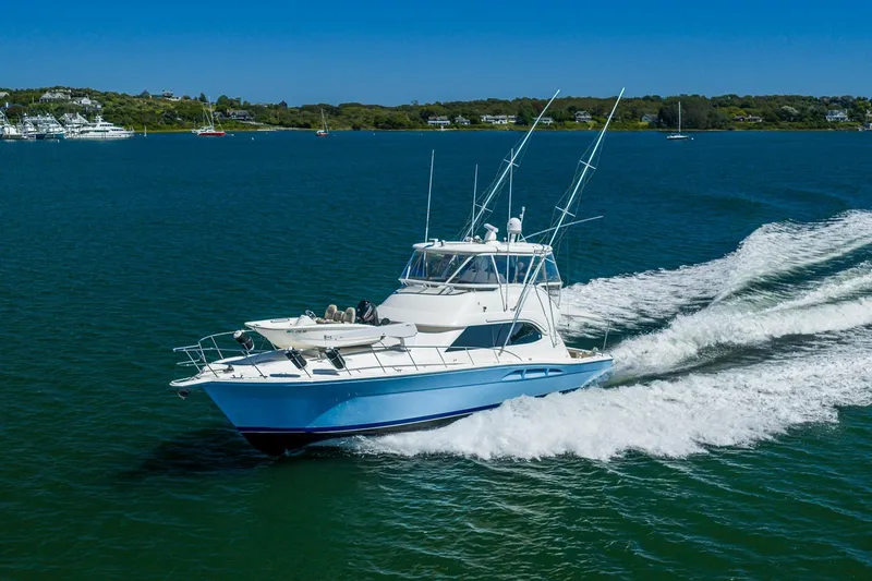 Chillax Yacht Photos Pics 2005 Riviera 51 Flybridge yacht cruising on open water, creating a wake.