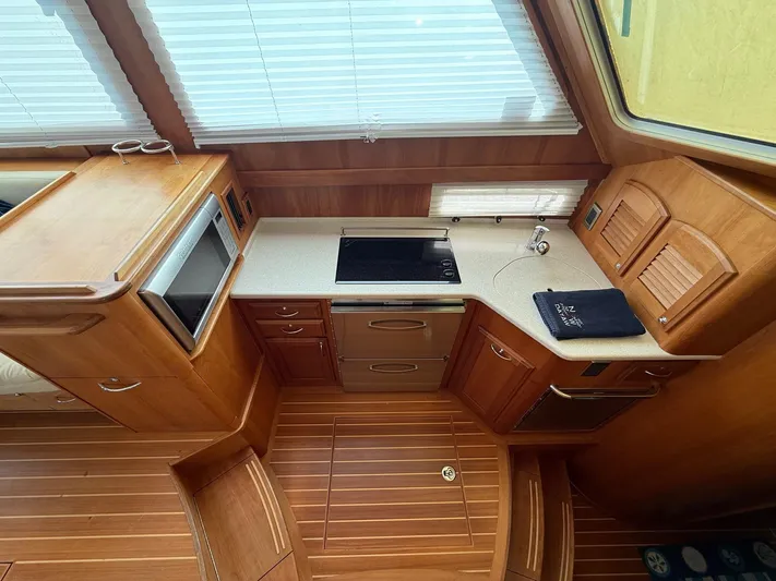 We''ll Sea Yacht Photos Pics Interior of 2011 Sabre 40 Sedan yacht kitchen with wooden cabinetry and modern appliances.