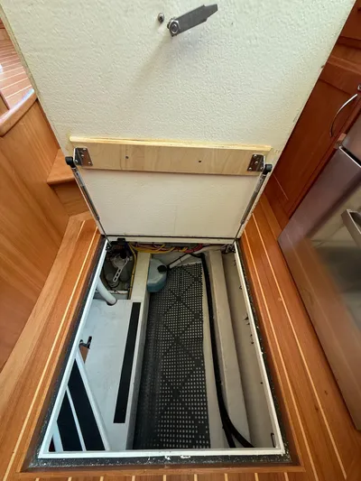 We''ll Sea Yacht Photos Pics Open hatch in 2011 Sabre 40 Sedan, revealing storage compartment and wiring.