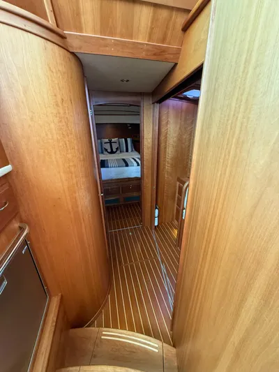 We''ll Sea Yacht Photos Pics Interior hallway of 2011 Sabre 40 Sedan yacht with wooden finish and cozy bedroom.