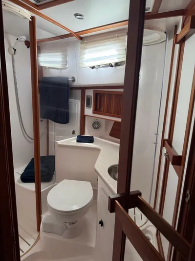 We''ll Sea Yacht Photos Pics 2011 Sabre 40 Sedan yacht bathroom with shower, toilet, and wooden accents.