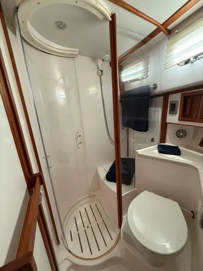 We''ll Sea Yacht Photos Pics 2011 Sabre 40 Sedan bathroom with shower, toilet, and wooden accents.