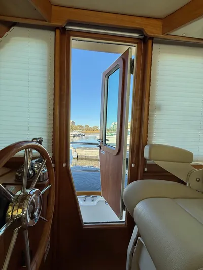 We''ll Sea Yacht Photos Pics Interior view of 2011 Sabre 40 Sedan yacht, showcasing helm and open door to marina.