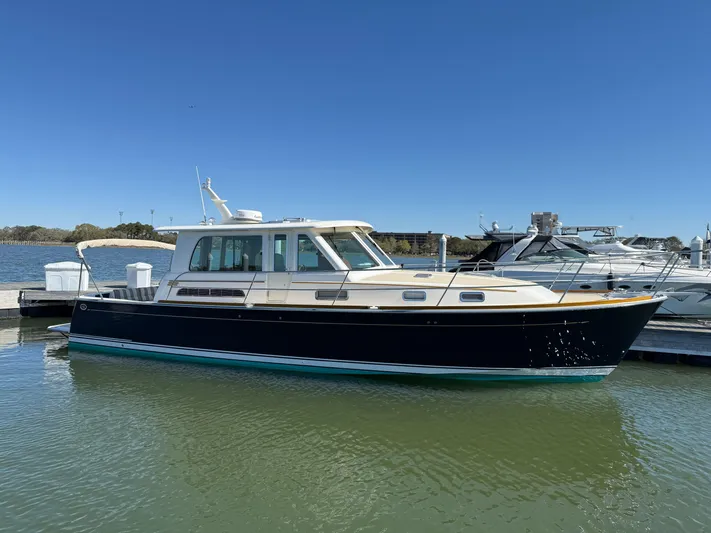 We''ll Sea Yacht Photos Pics 2011 Sabre 40 Sedan boat docked in a marina under clear blue skies.