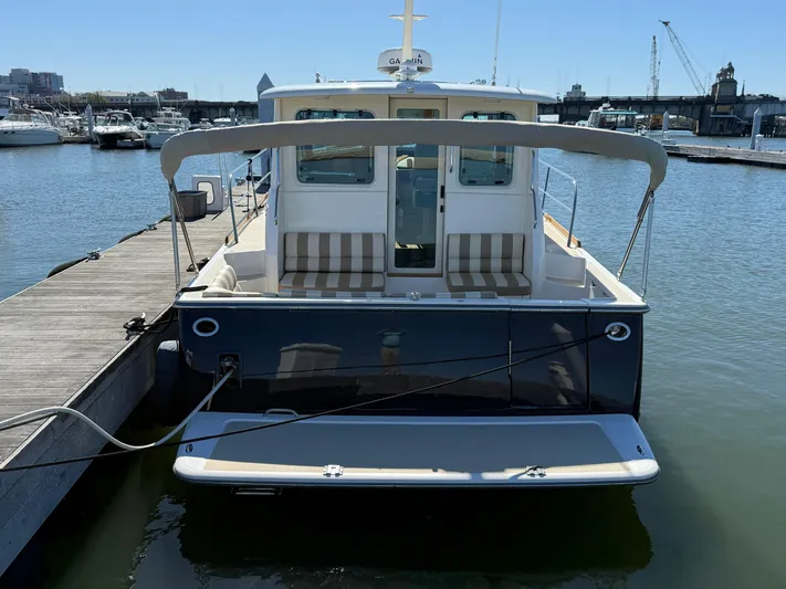 We''ll Sea Yacht Photos Pics 2011 Sabre 40 Sedan docked at marina, rear view with striped seating.