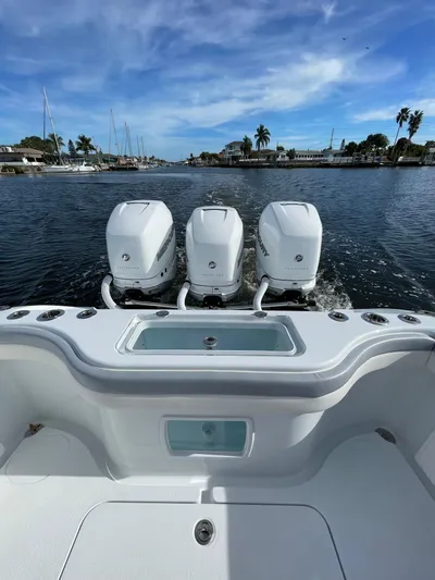  Yacht Photos Pics 2022 Yellowfin 34 boat with triple outboard engines on a scenic waterway.