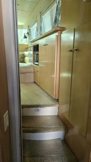 Elusive Yacht Photos Pics Interior view of 1997 Carver 500 Cockpit Motor Yacht with carpeted stairs and wooden cabinets.