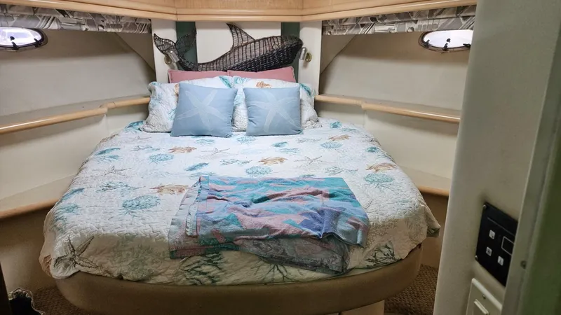 Elusive Yacht Photos Pics Cozy bedroom in 1997 Carver 500 Cockpit Motor Yacht with nautical-themed bedding.