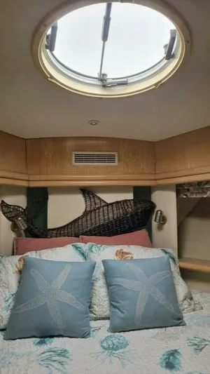 Elusive Yacht Photos Pics Cozy cabin interior of 1997 Carver 500 Cockpit Motor Yacht with nautical decor and porthole.