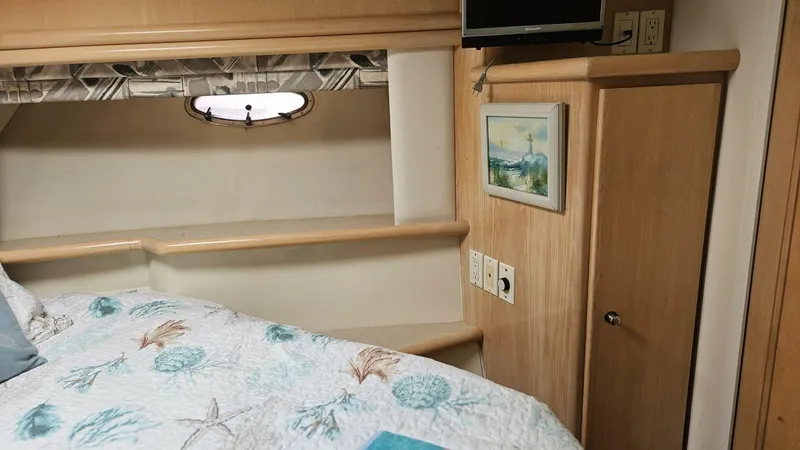 Elusive Yacht Photos Pics Cozy bedroom in 1997 Carver 500 Cockpit Motor Yacht with nautical decor and porthole window.