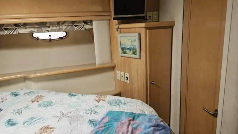 Elusive Yacht Photos Pics Cozy cabin interior of 1997 Carver 500 Cockpit Motor Yacht with bed and porthole.